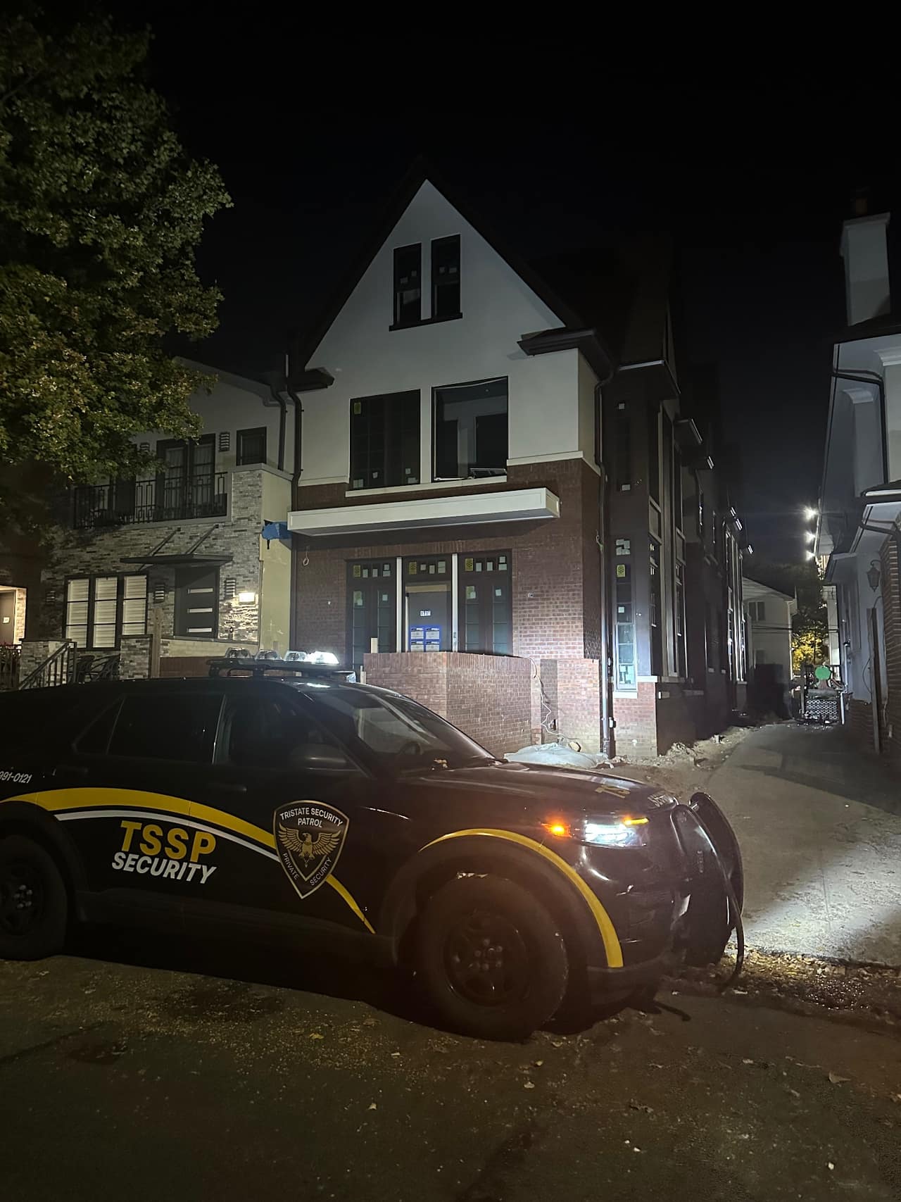 Tristate patrol vehicle stopped with lights on in front of a residential home during an overnight pass